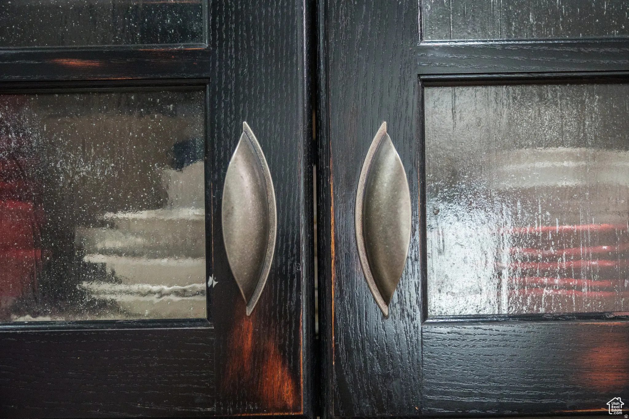 Dark wood-finish cabinetry featuring textured glass panels and brushed metal pull handles