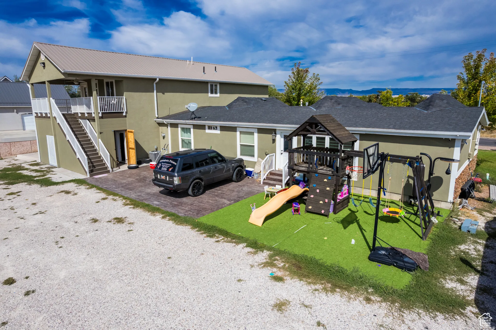 Multi-level exterior with a light green stucco finish