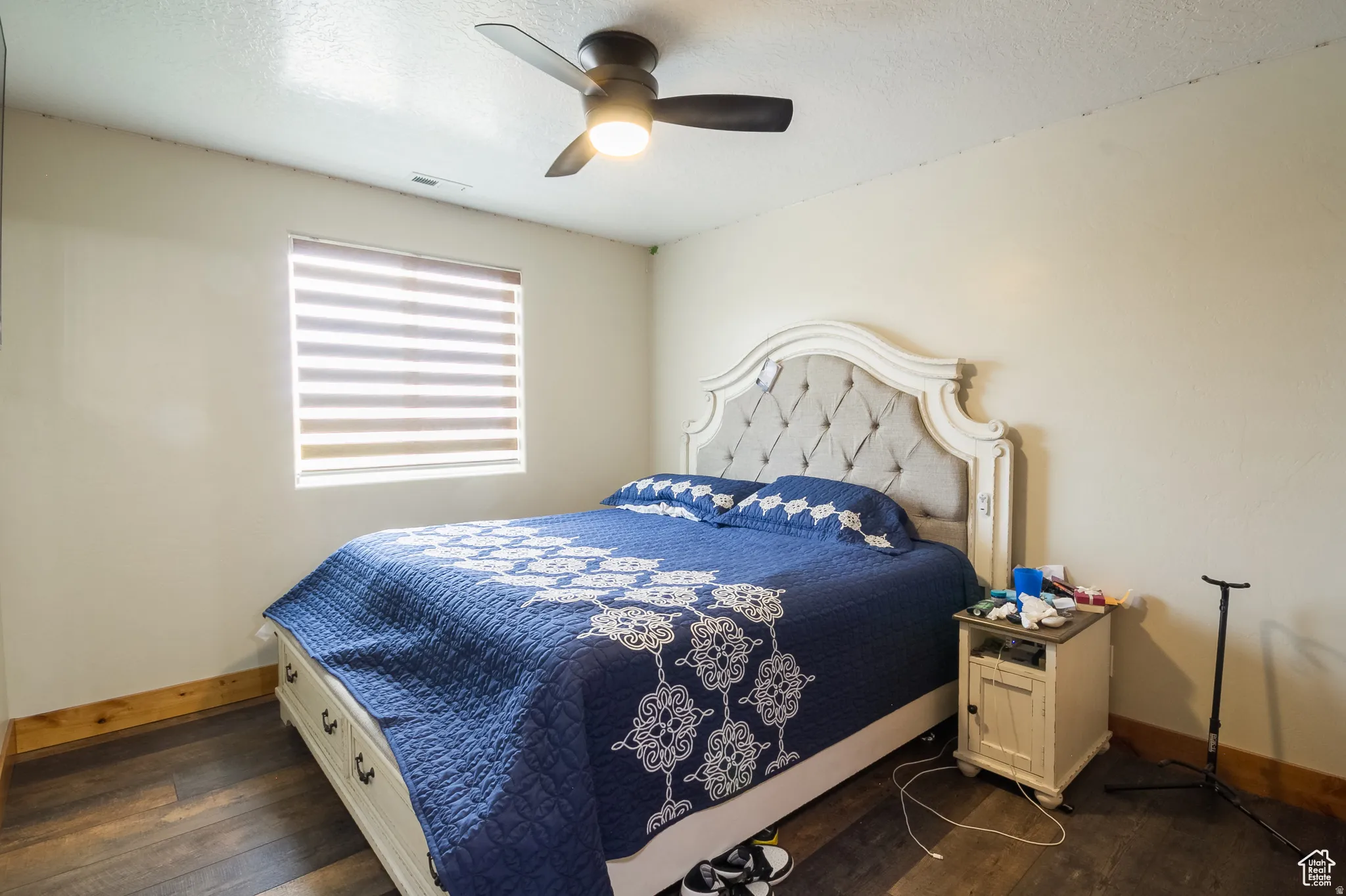Bedroom featuring dark wood-finish flooring and a ceiling fan with integrated lighting