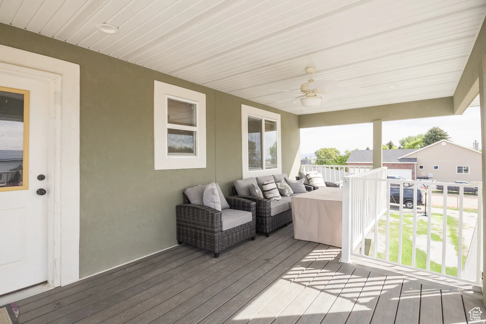 Covered porch with wood-finish decking and a ceiling fan