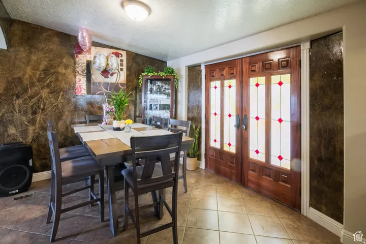 Entryway featuring ornate double doors with stained glass accents, set against textured wall finishes