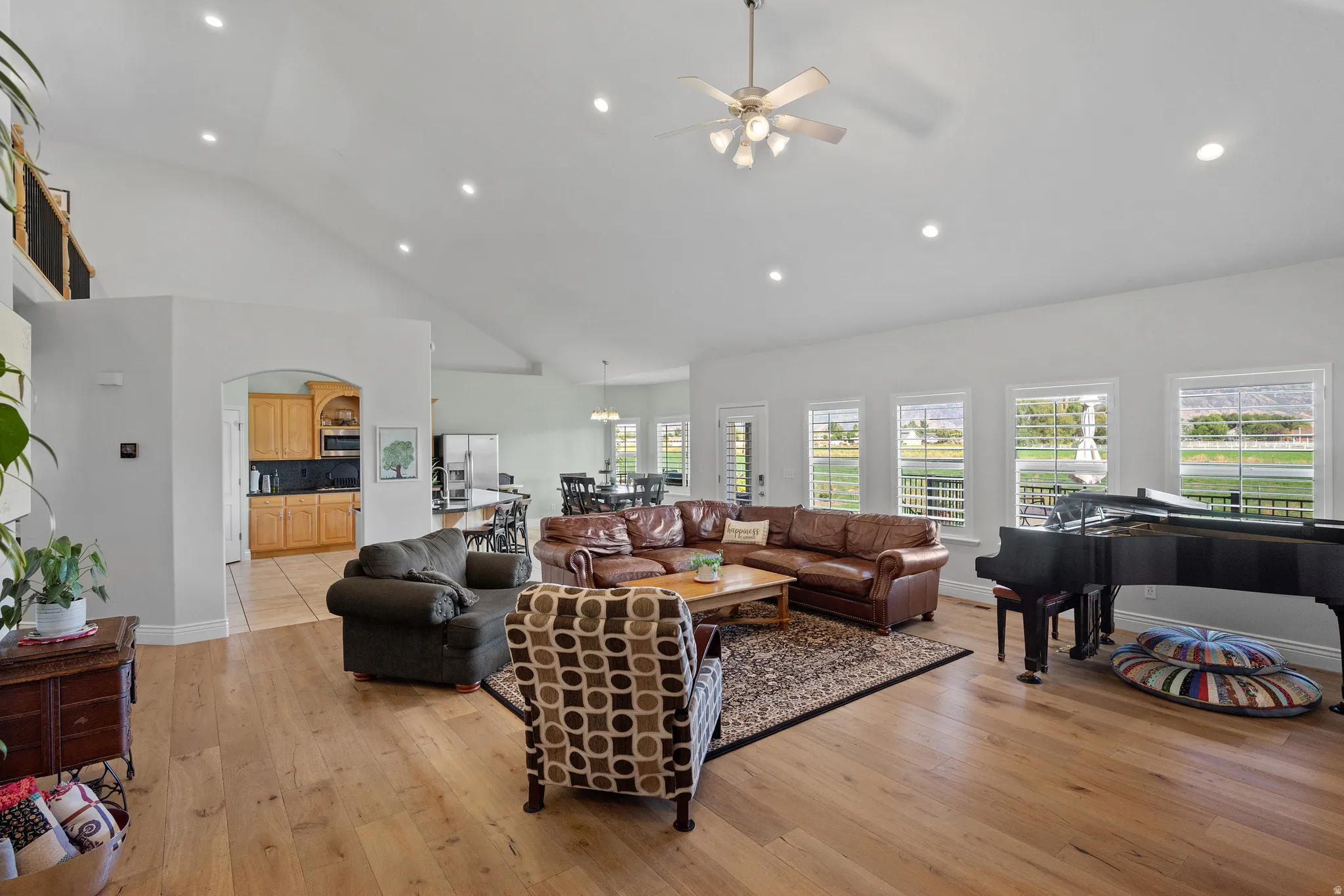 Expansive living area featuring vaulted ceilings, recessed lighting, and wood-finish flooring