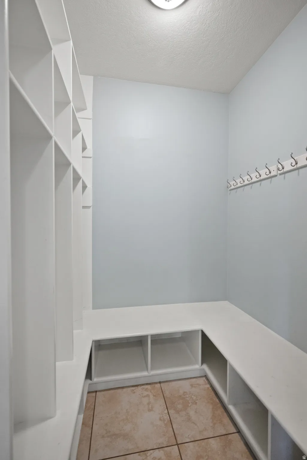 Built-in white cubby storage and bench seating complement the light blue walls