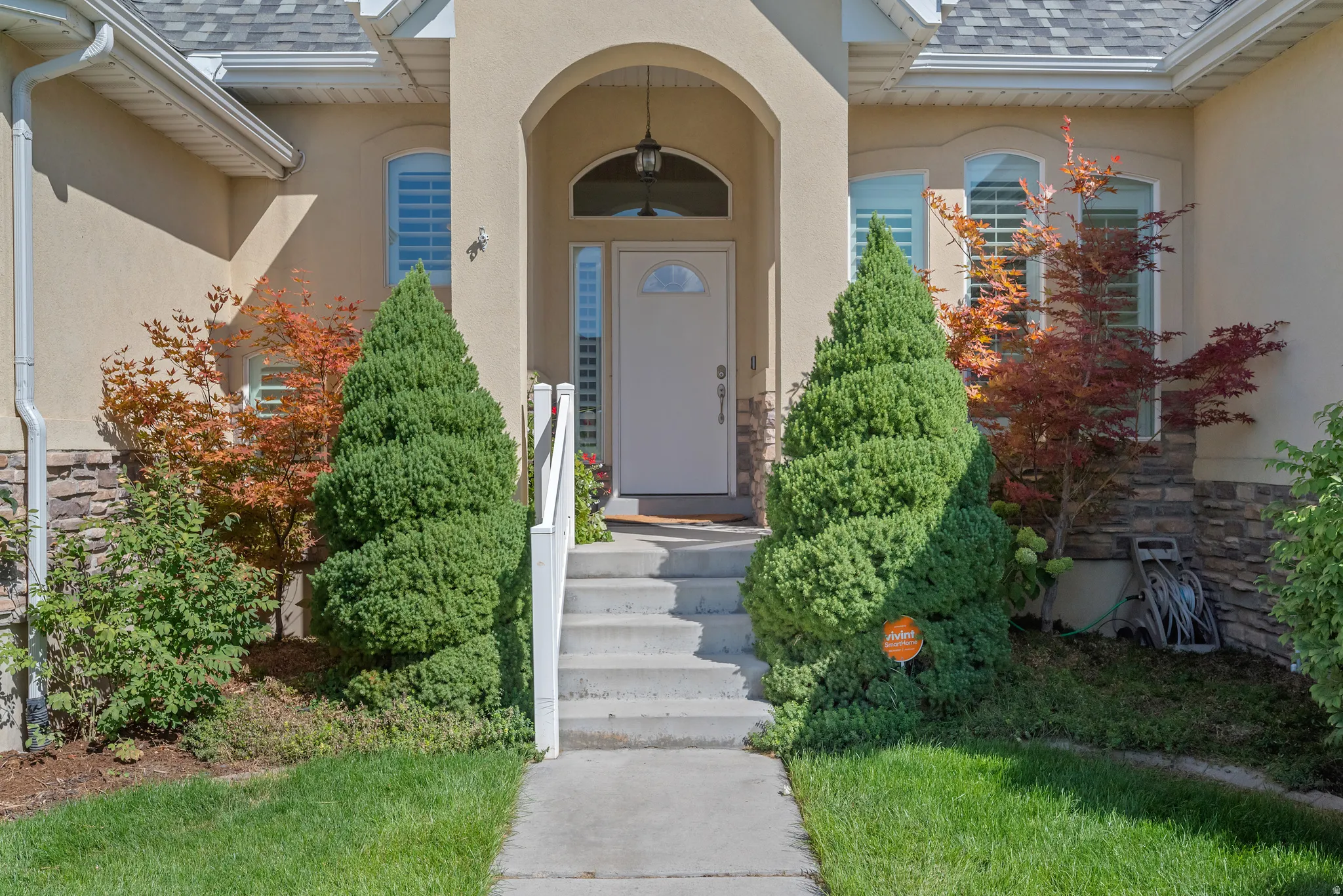 Inviting stucco exterior with stone accents and a covered entryway
