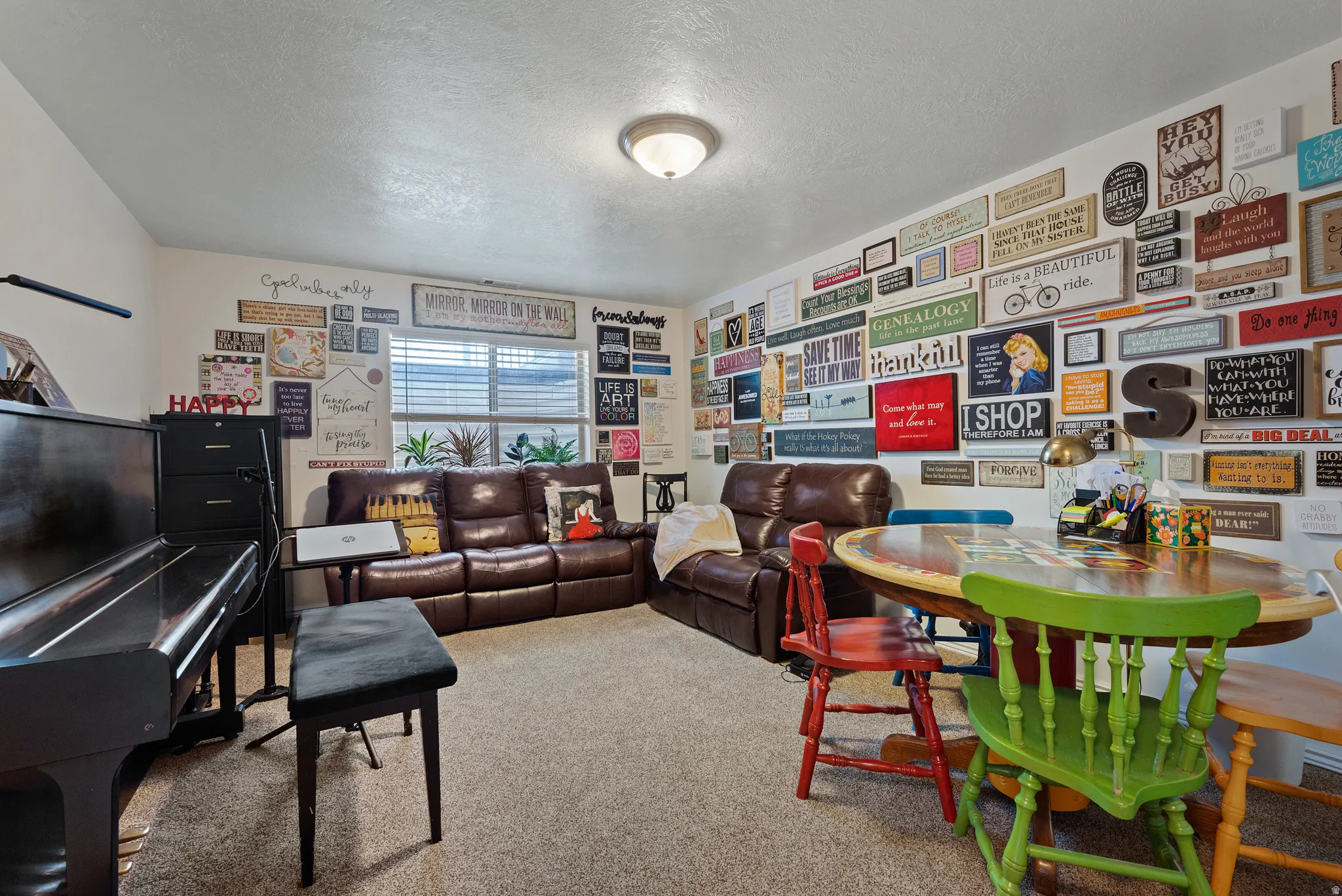 Carpeted interior space featuring a ceiling-mounted light fixture, horizontal window blinds, and a built-in wall display