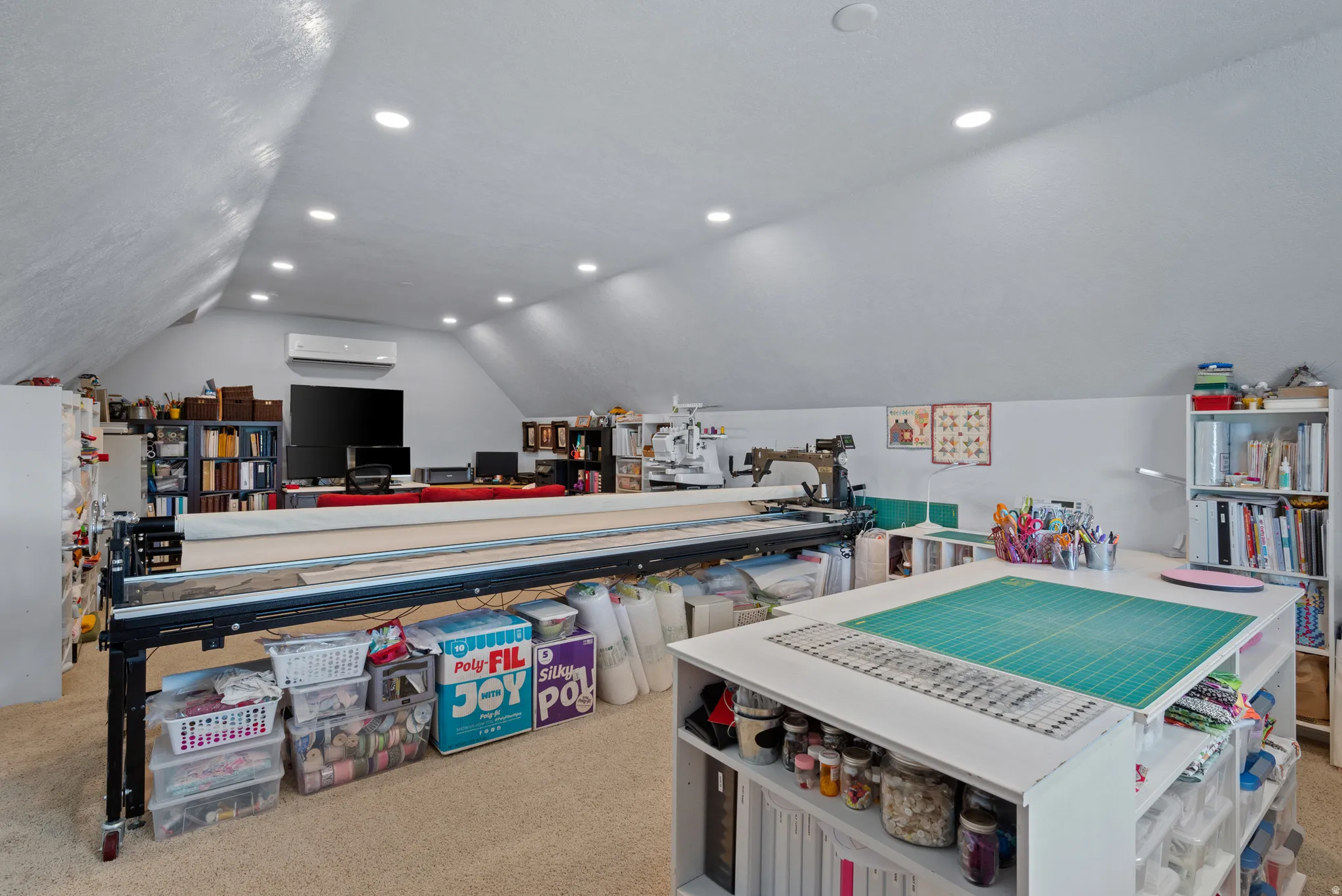 Versatile attic space featuring sloped ceilings, recessed lighting, and light-tone carpeting
