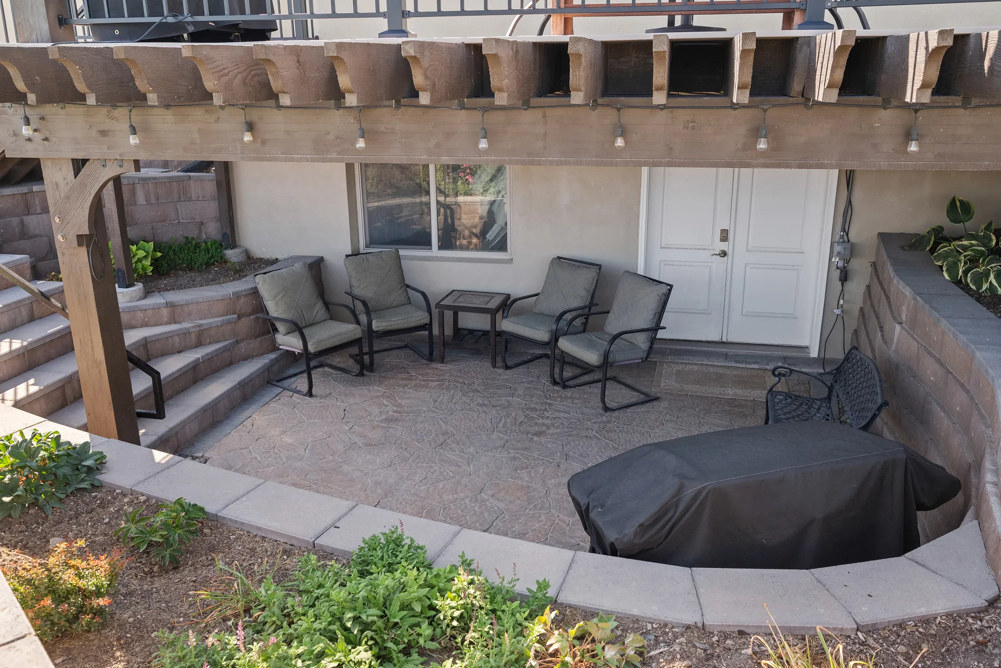 Expansive stamped concrete patio featuring a wood pergola with integrated lighting