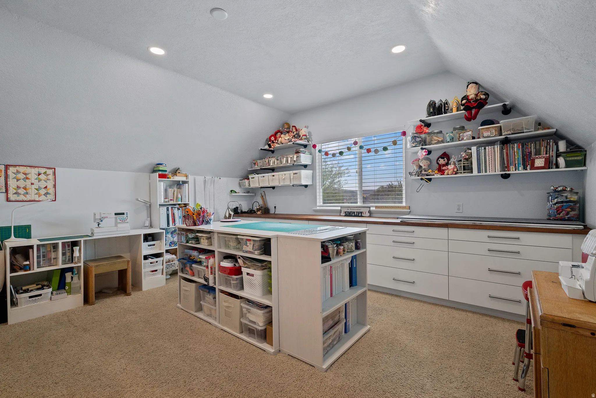 Attic space featuring sloped ceilings, recessed lighting, and carpeted flooring