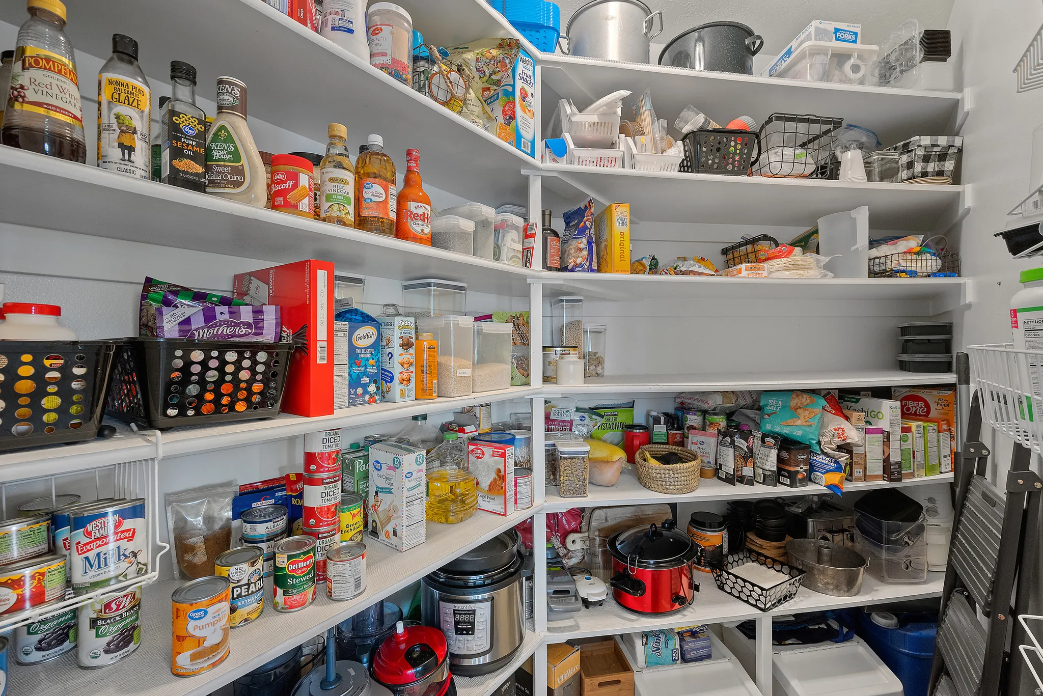 Pantry featuring floor-to-ceiling white shelving and ample storage capacity