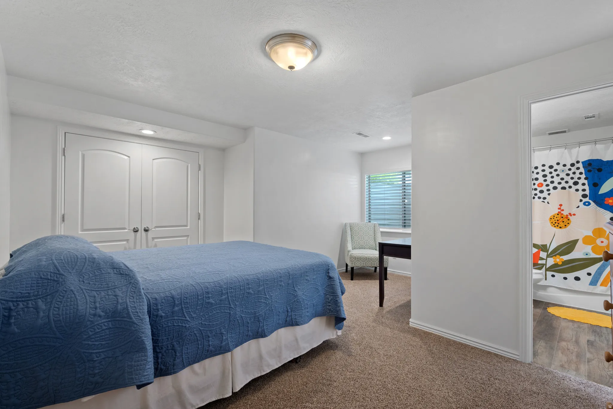 Carpeted bedroom featuring white walls and a ceiling-mounted light fixture