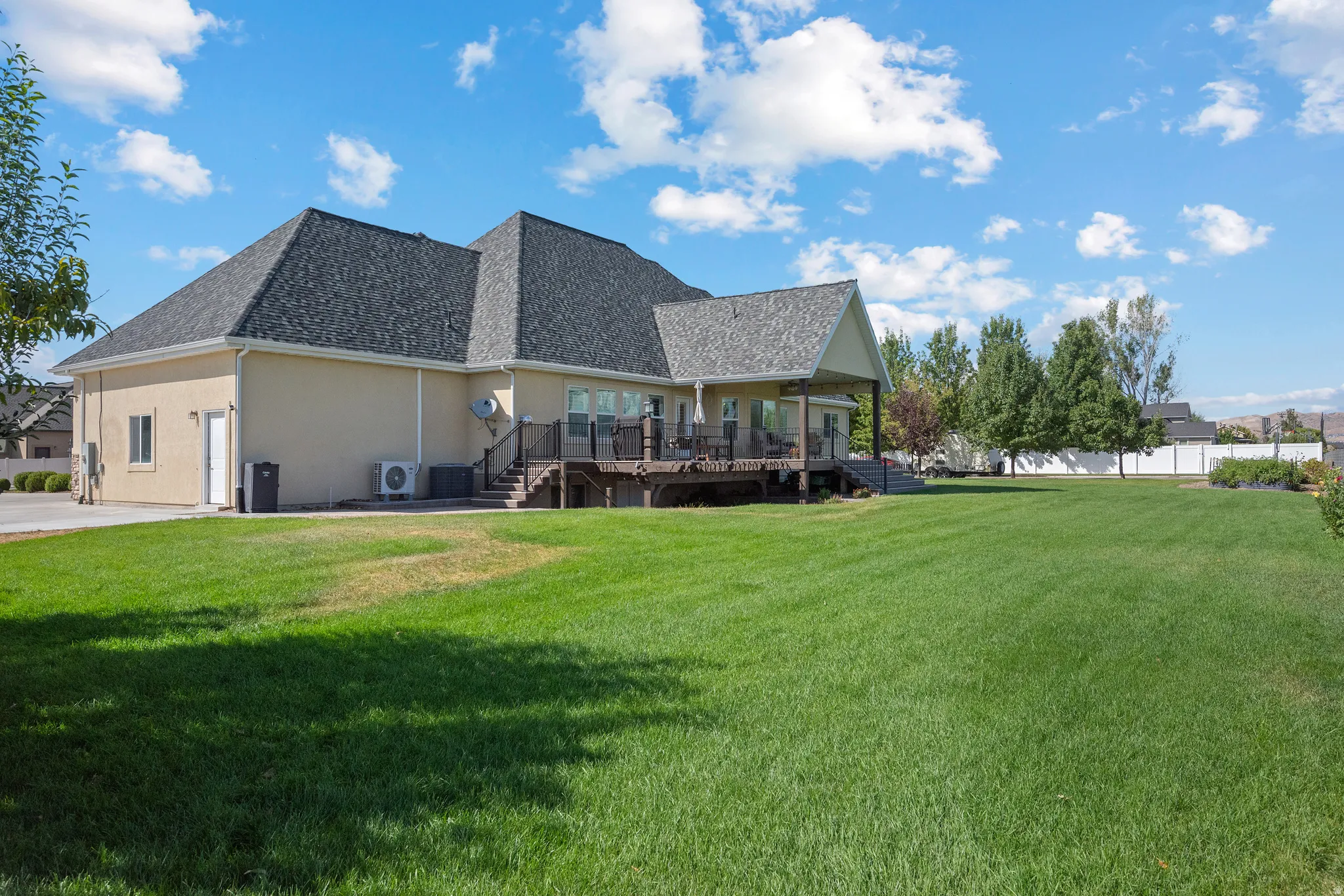 Expansive green lawn with a white privacy fence
