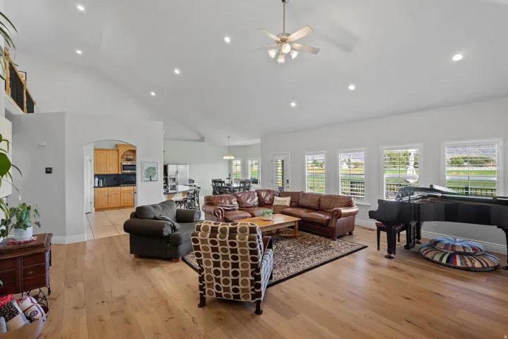 Expansive living area featuring vaulted ceilings, recessed lighting, and wood-finish flooring