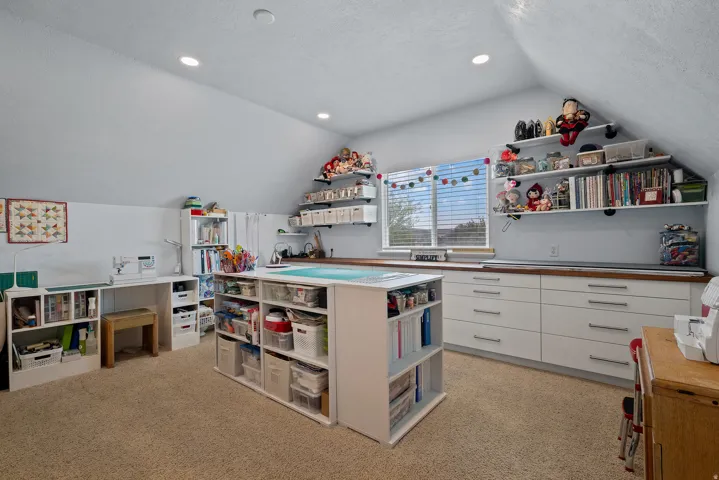 Attic space featuring sloped ceilings, recessed lighting, and carpeted flooring
