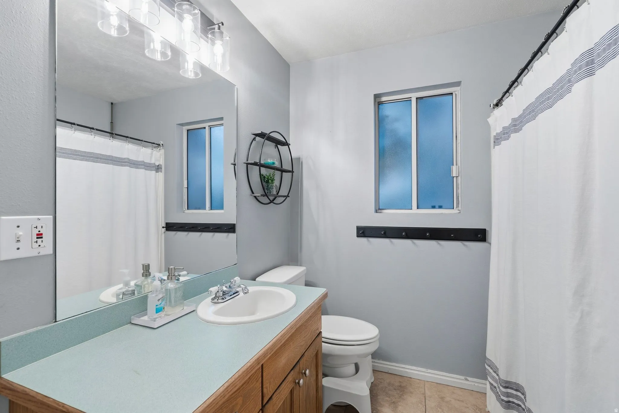 Bathroom vanity with an integrated sink and updated lighting.