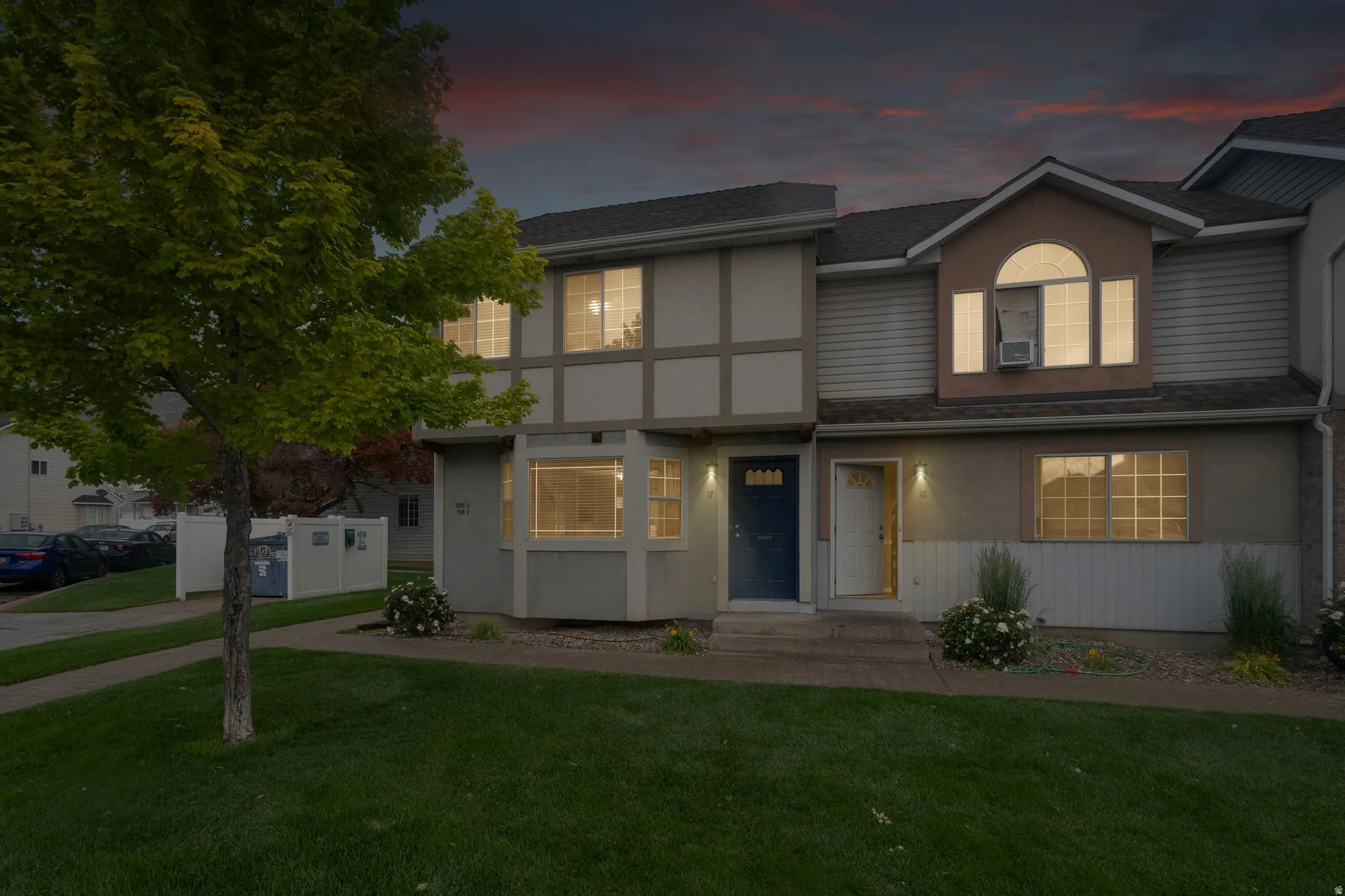 Townhouse exterior featuring a combination of stucco and horizontal siding, a pitched shingle roof, and multiple windows