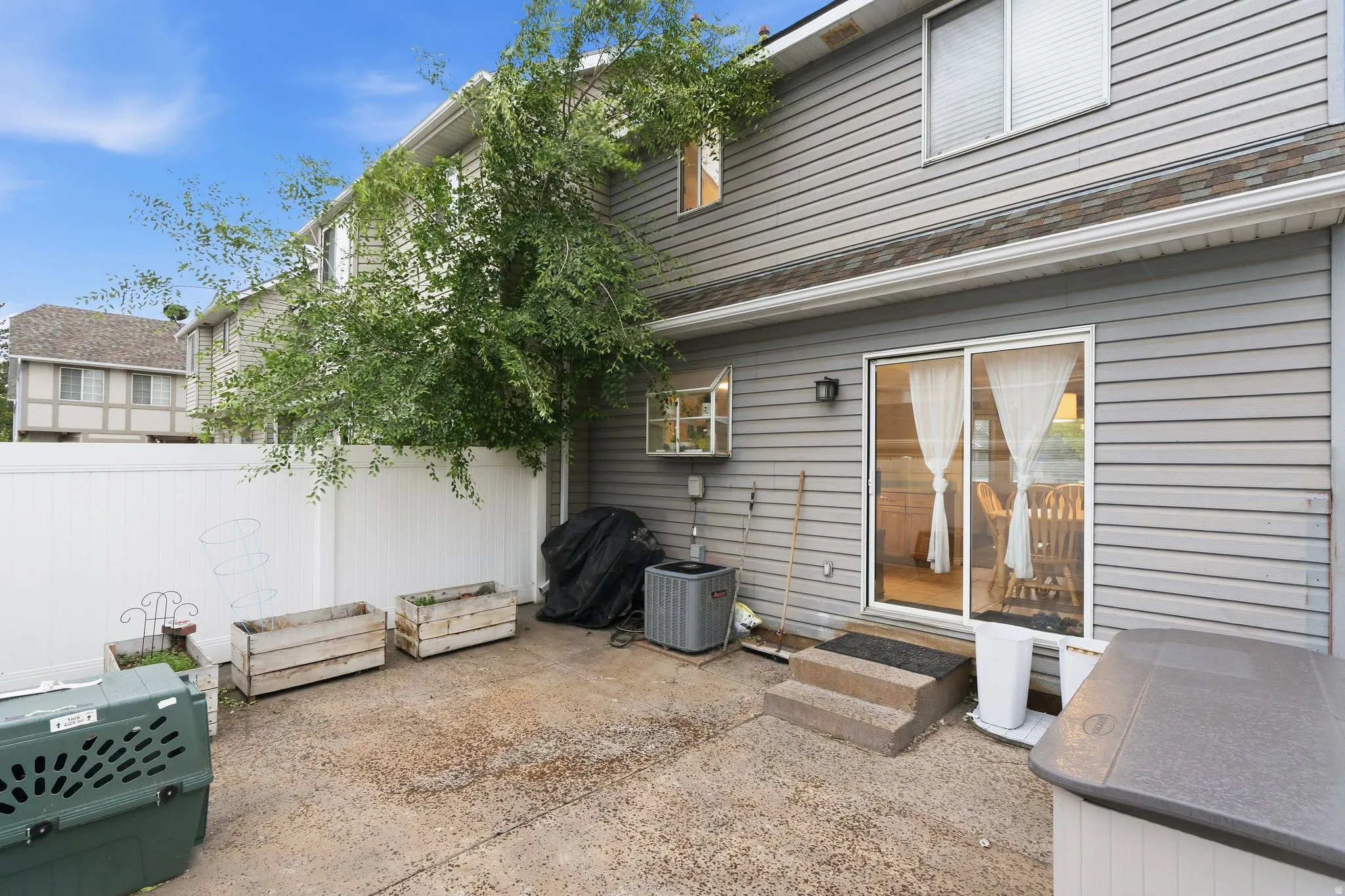 Private outdoor patio area with white vinyl fencing