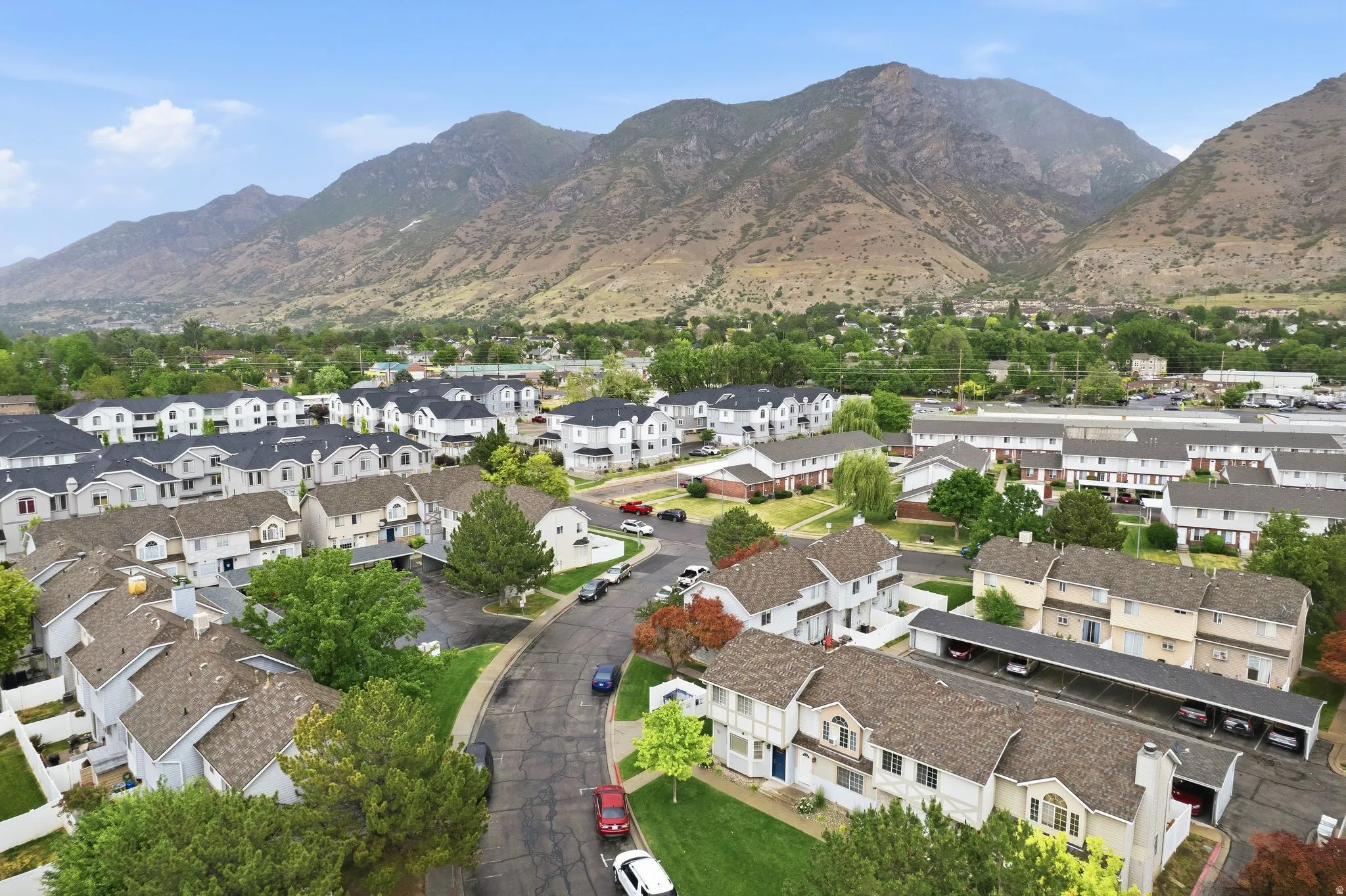 Residential community with a mountain backdrop, featuring townhomes and individual residences