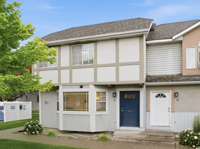 Two-story multi-unit dwelling with pitched roofs and composition shingles