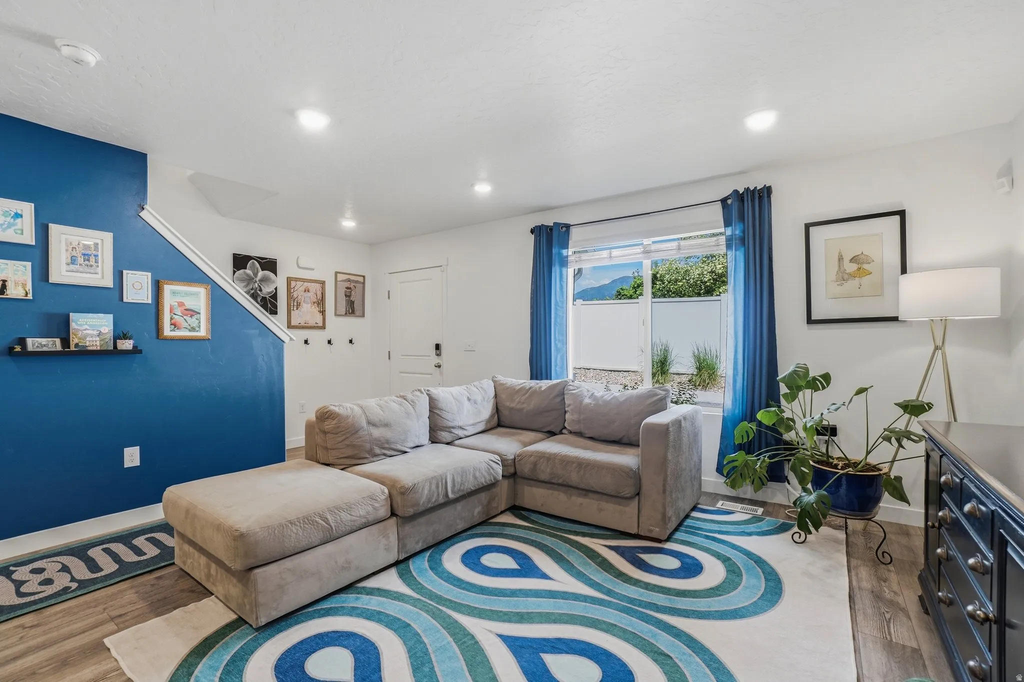 Living area featuring wood-finish flooring, recessed lighting, and a large sliding glass door