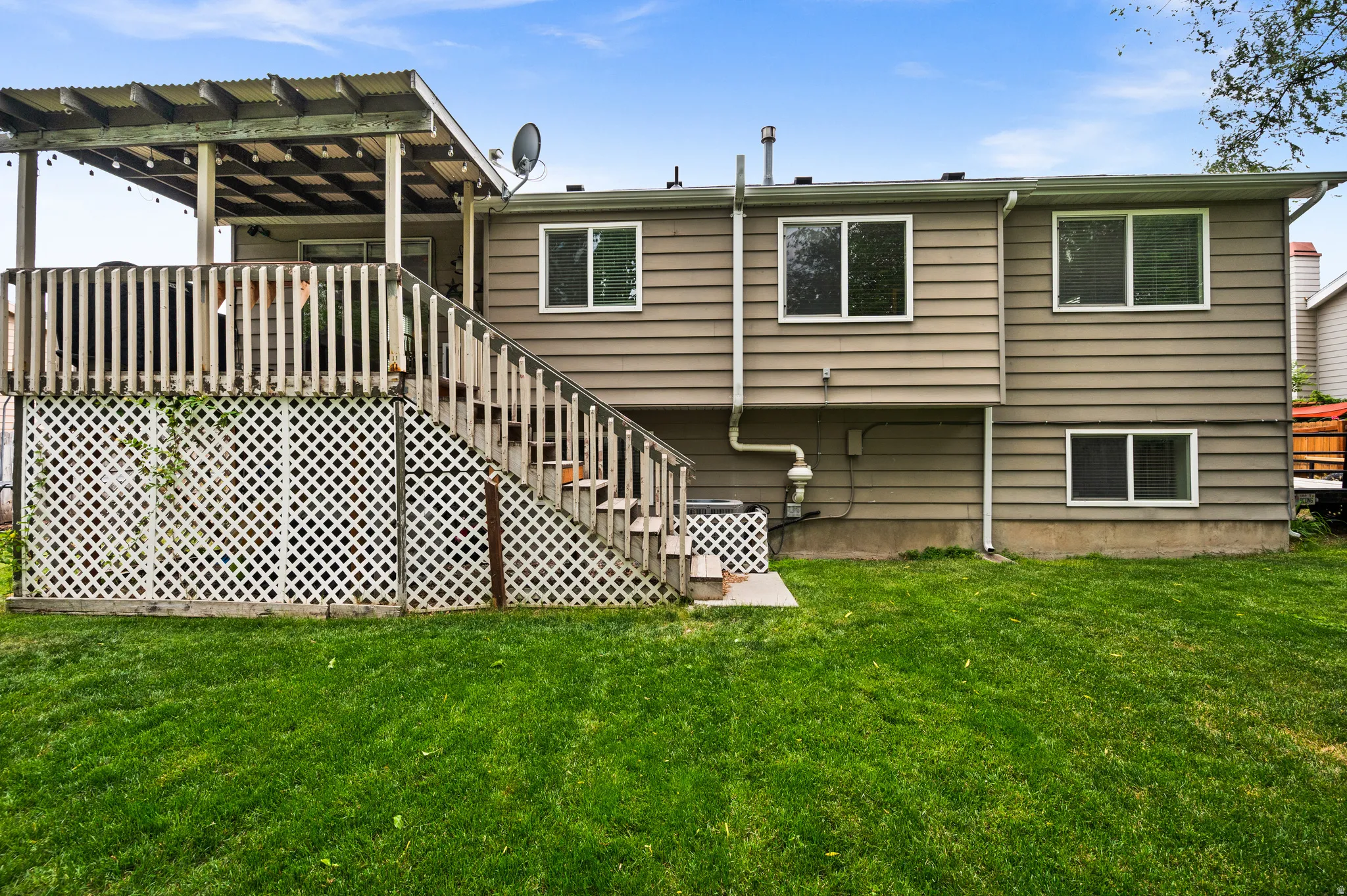 Expansive green lawn with a two-story residence featuring horizontal siding