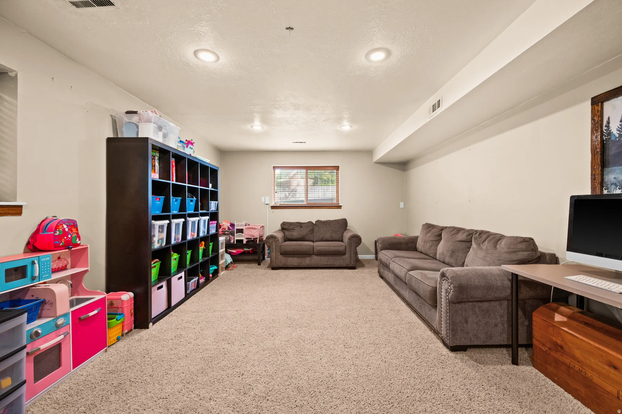 Spacious lower-level room featuring recessed lighting, light-colored walls, and neutral carpeting