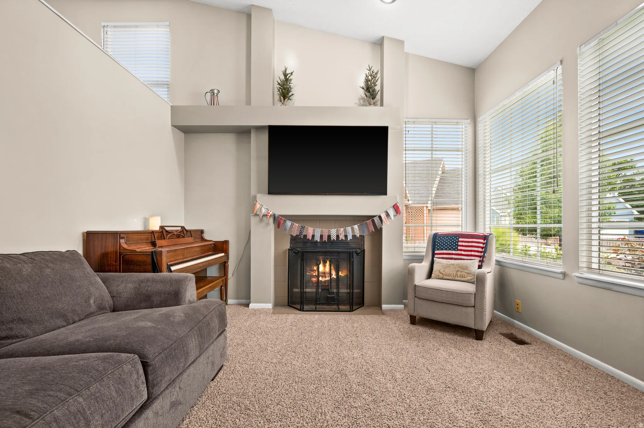 Living area with vaulted ceilings, a built-in fireplace, and expansive windows