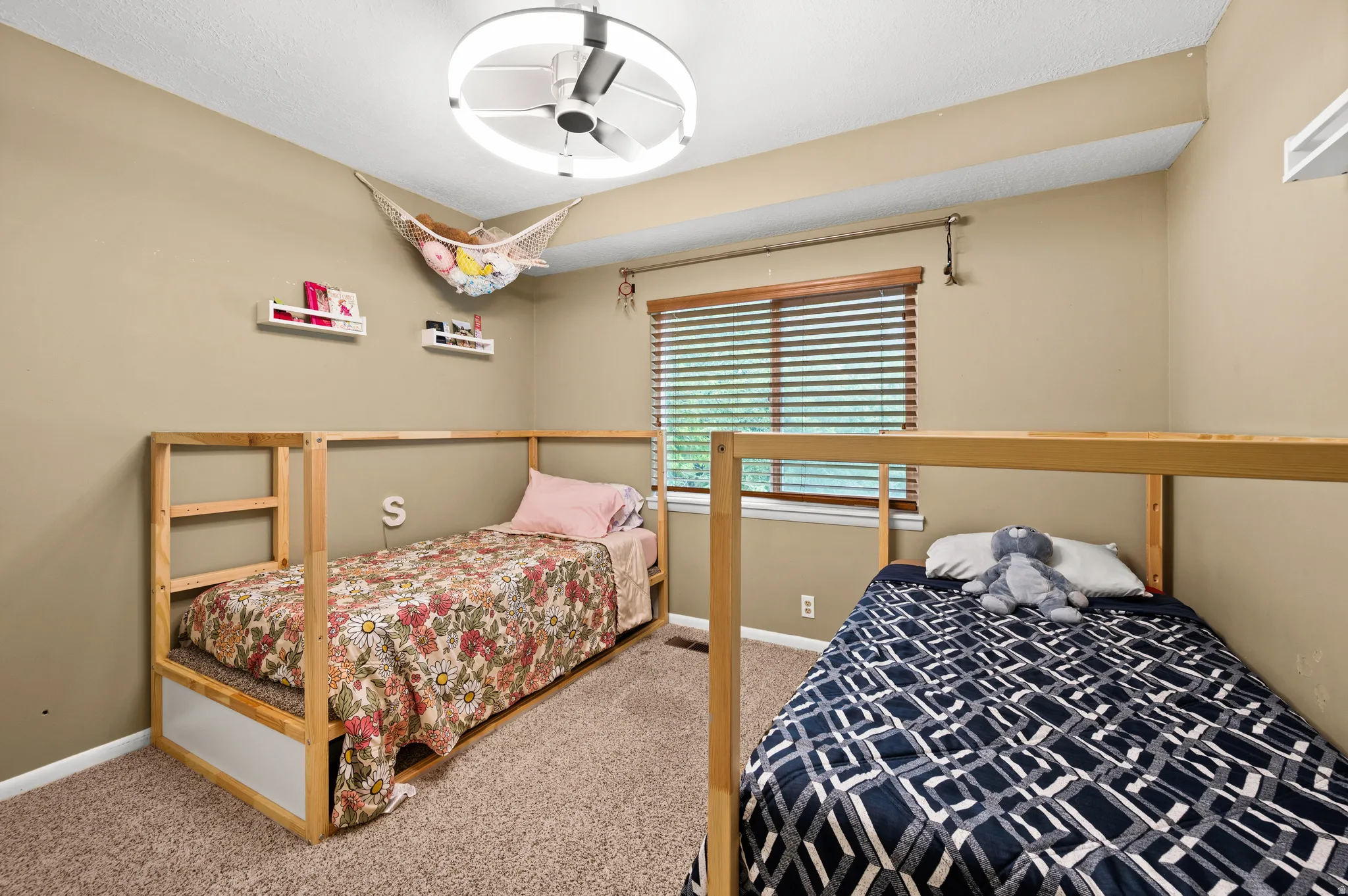 Carpeted room featuring a ceiling fan with integrated lighting, a window with wood blinds, and neutral wall tones