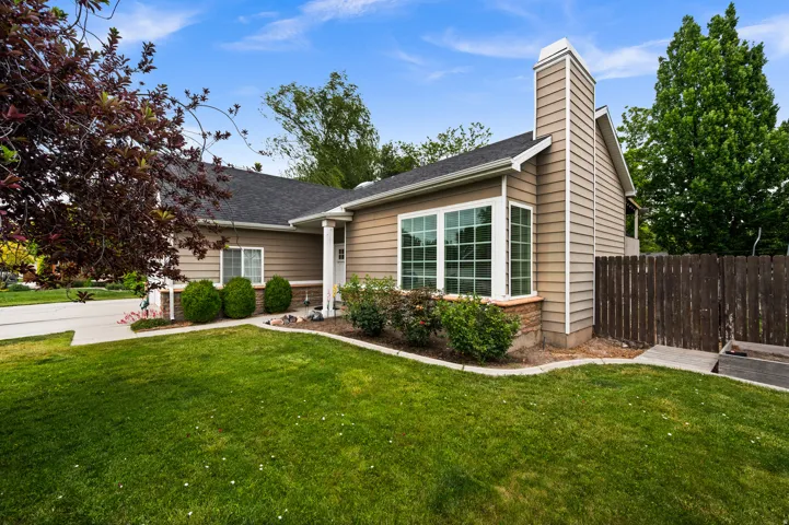 Single-story residence featuring light brown siding and a dark shingle roof