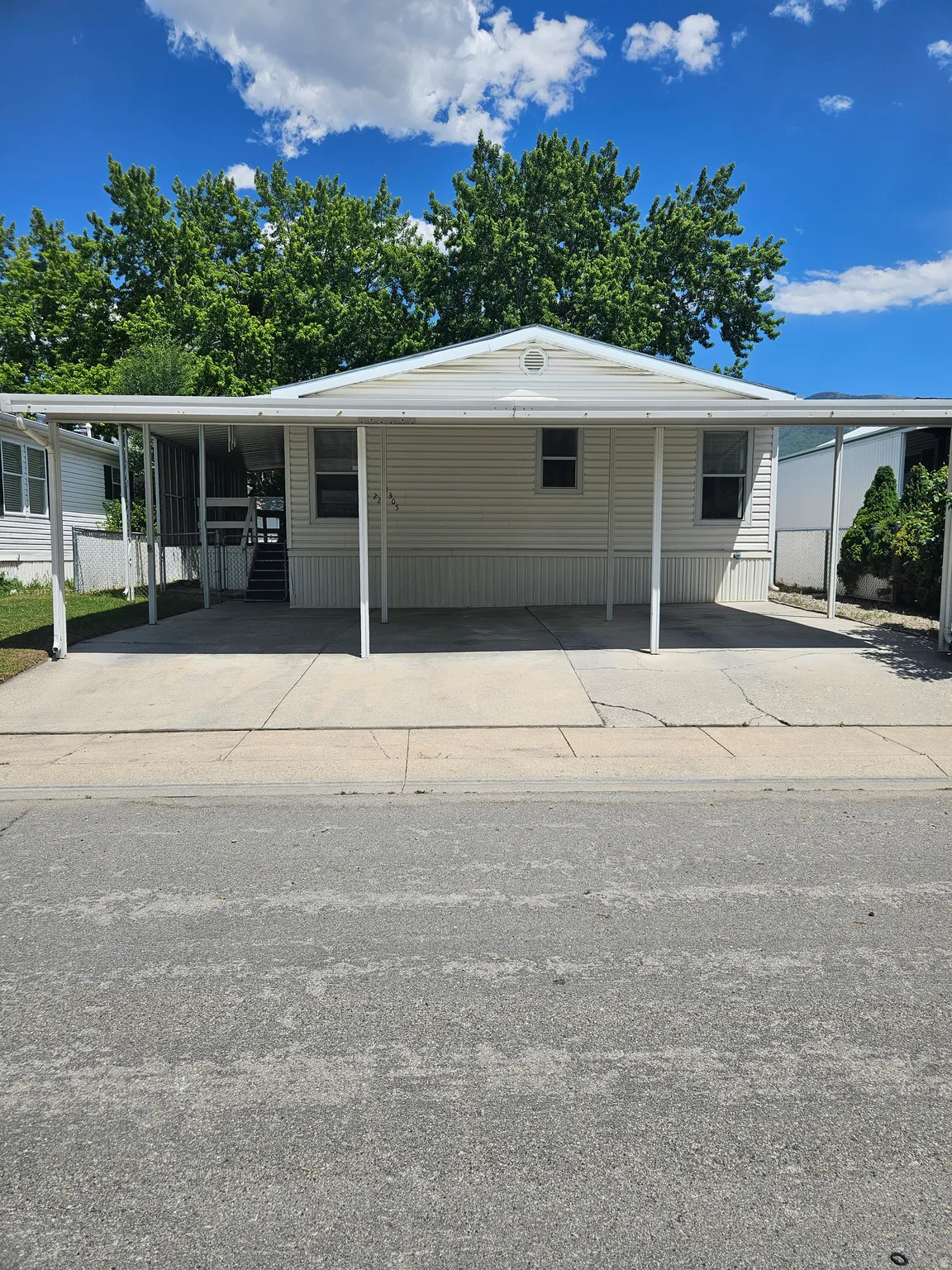 Single-story residence featuring white vinyl siding and a gable roof with a central vent