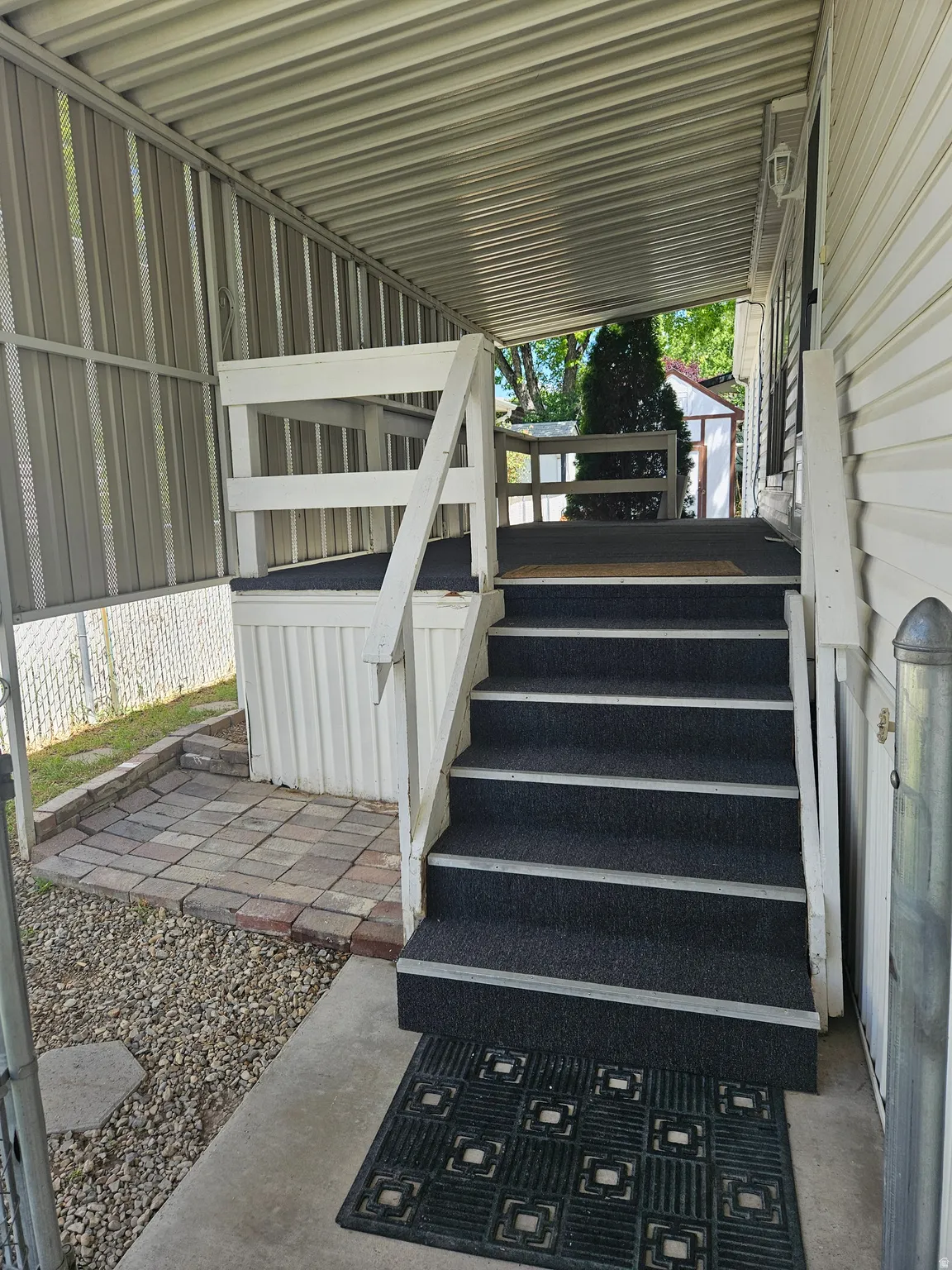 Covered entry porch featuring white railing