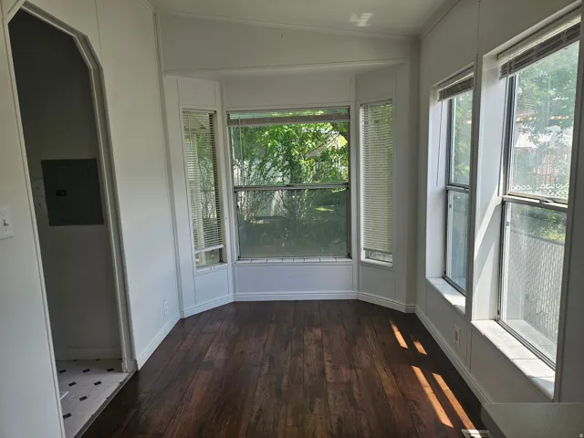 Bay window alcove featuring wood-finish flooring and multiple windows