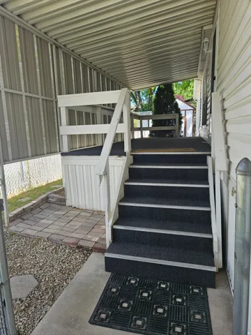 Covered entry porch featuring white railing