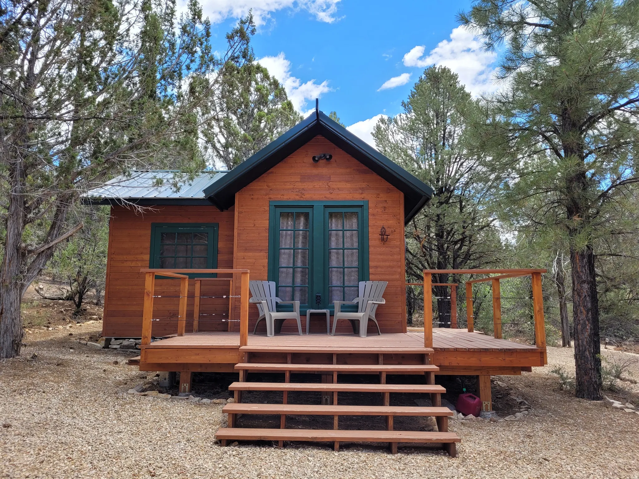 Wood-sided cabin featuring a metal roof and an elevated wood deck