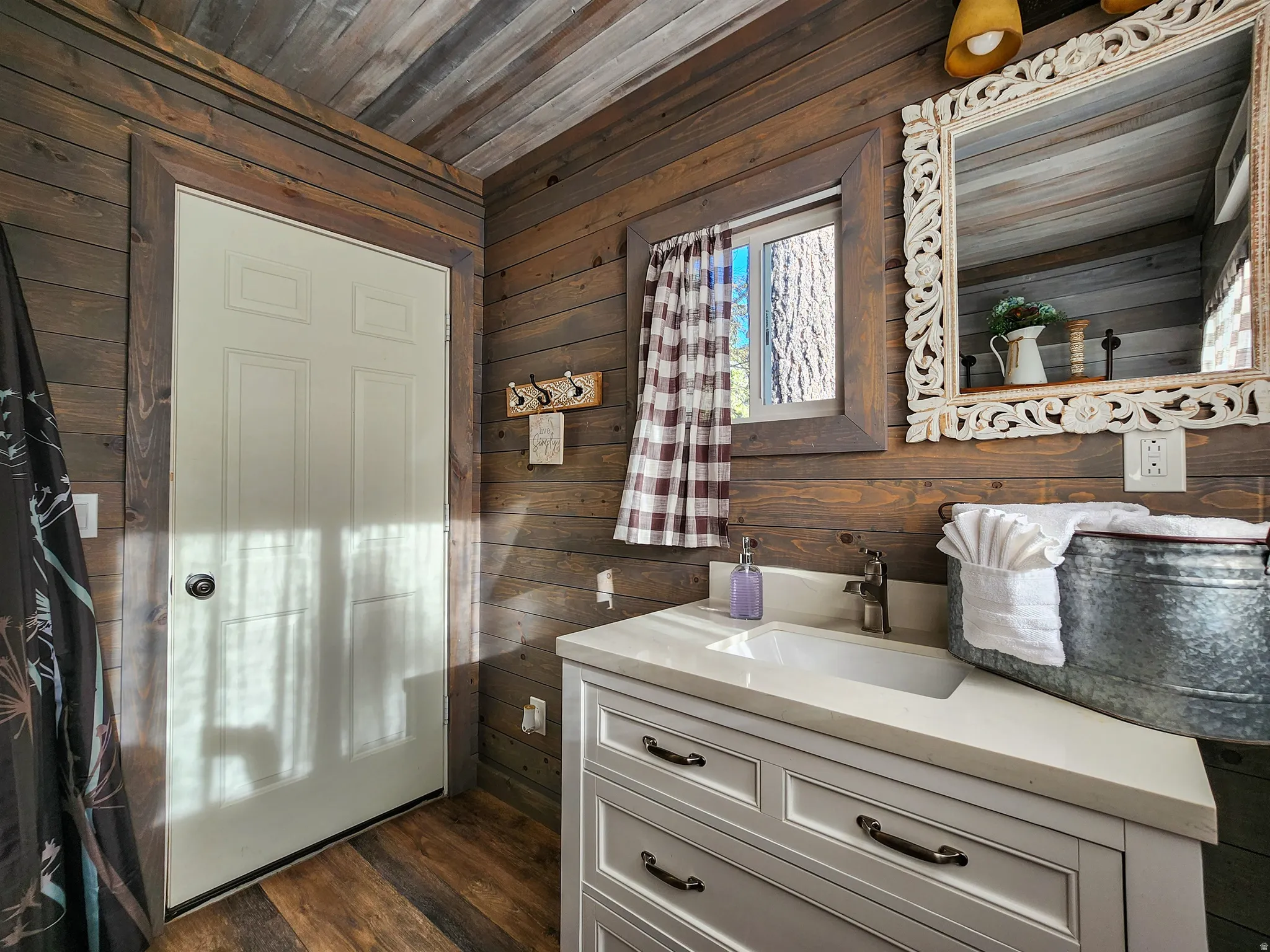 Wood-paneled bathroom featuring a single vanity with a white countertop and integrated sink