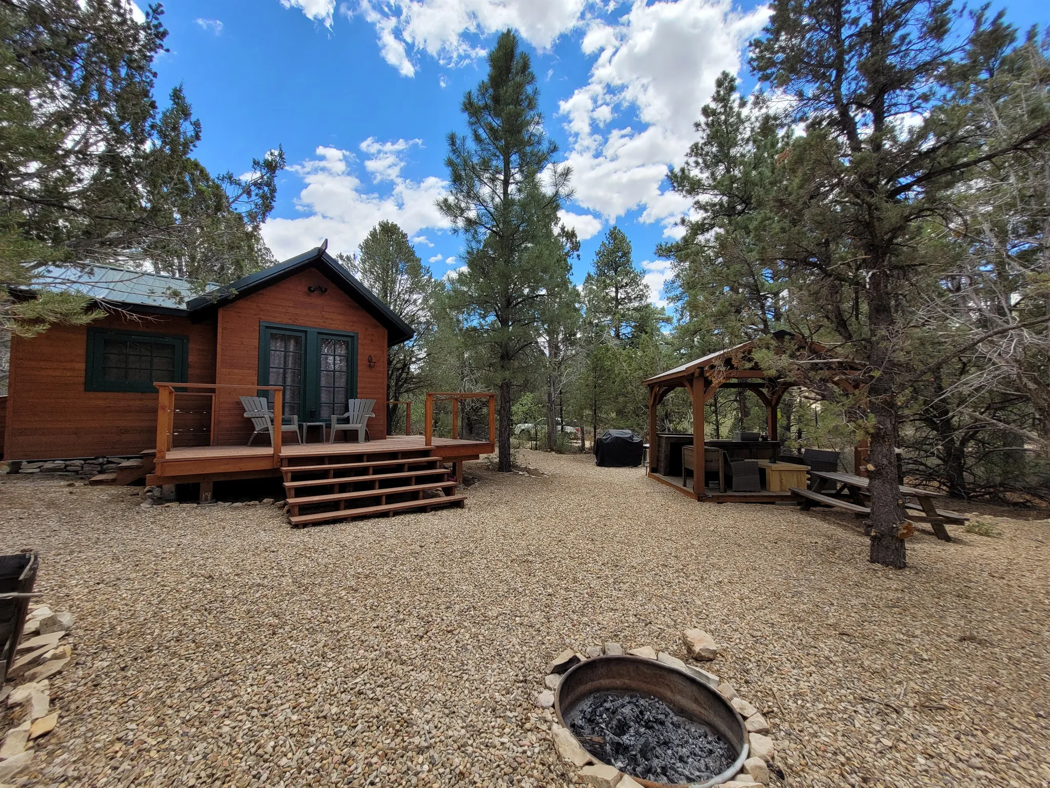 Wood-sided cabin with a front deck featuring double doors and a metal roof