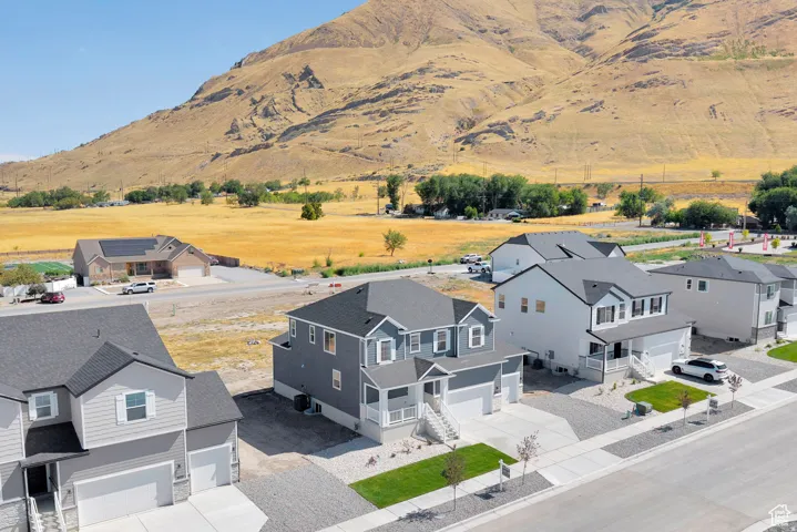 New construction residence featuring a gray exterior with white trim, a covered front porch, and an attached two-car garage