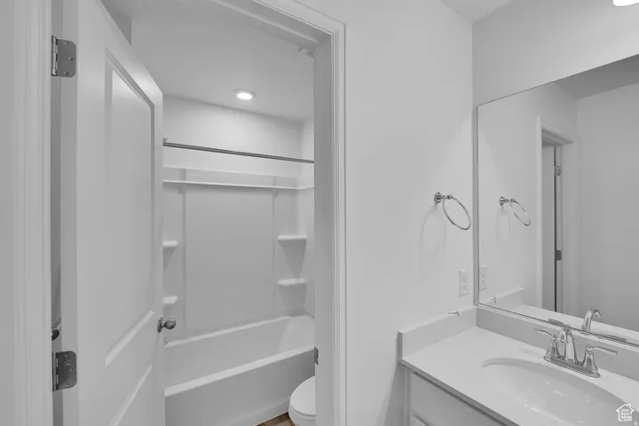 Bathroom featuring a vanity with an integrated sink, polished chrome faucet, and expansive mirror