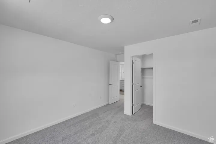 Neutral-toned carpet flooring and white painted walls characterize this interior space