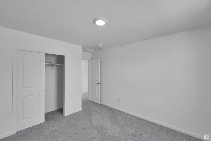 Room featuring light gray carpeting, crisp white walls, and a recessed ceiling light