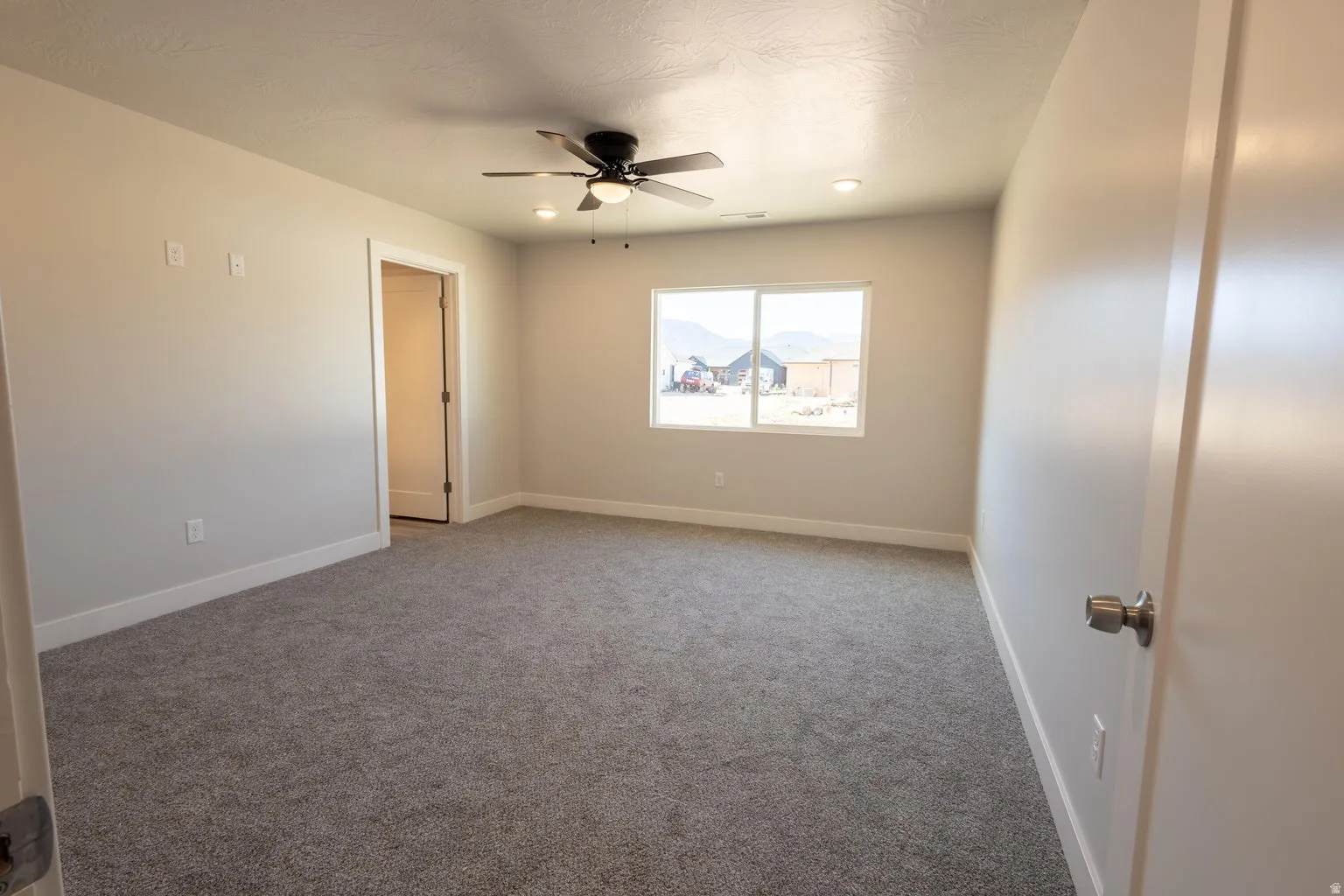Spacious room featuring neutral paint, gray carpet, a ceiling fan with integrated lighting, recessed lighting, and a large window