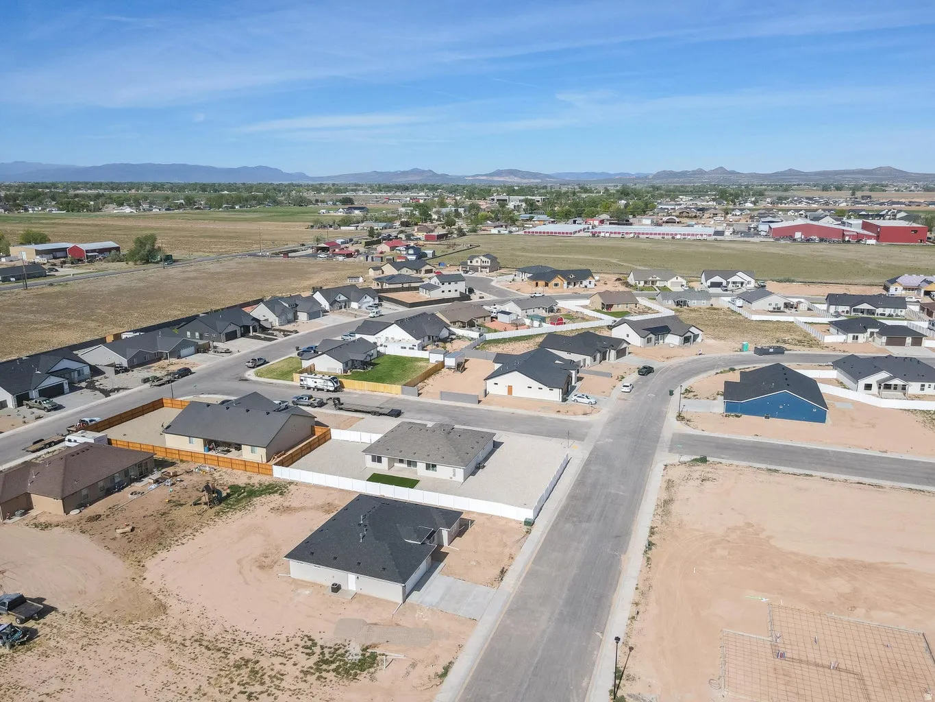 New construction residential development featuring a mix of single-story homes with dark shingle roofs