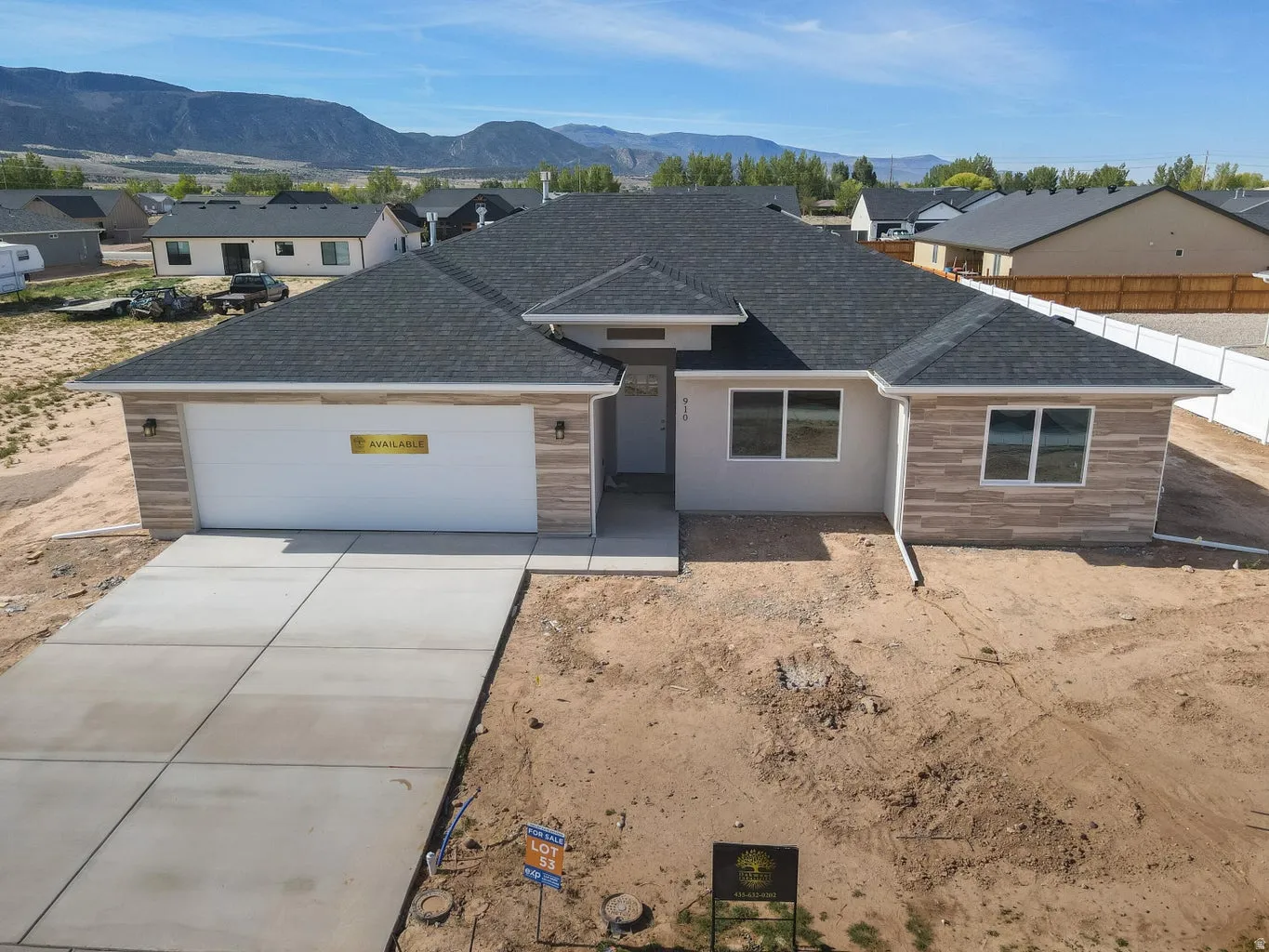 Contemporary single-story residence with a dark shingle roof and a light stucco exterior