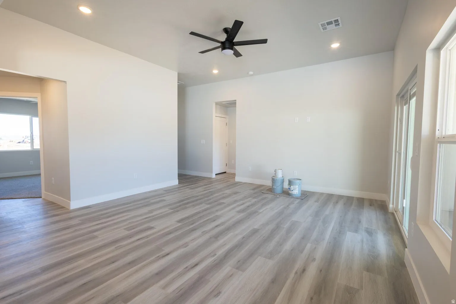 Spacious interior featuring wood-finish flooring, recessed lighting, and a contemporary ceiling fan