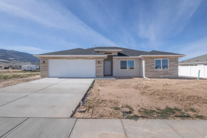 Contemporary single-story residence featuring a two-car garage, stone veneer accents, and a stucco exterior