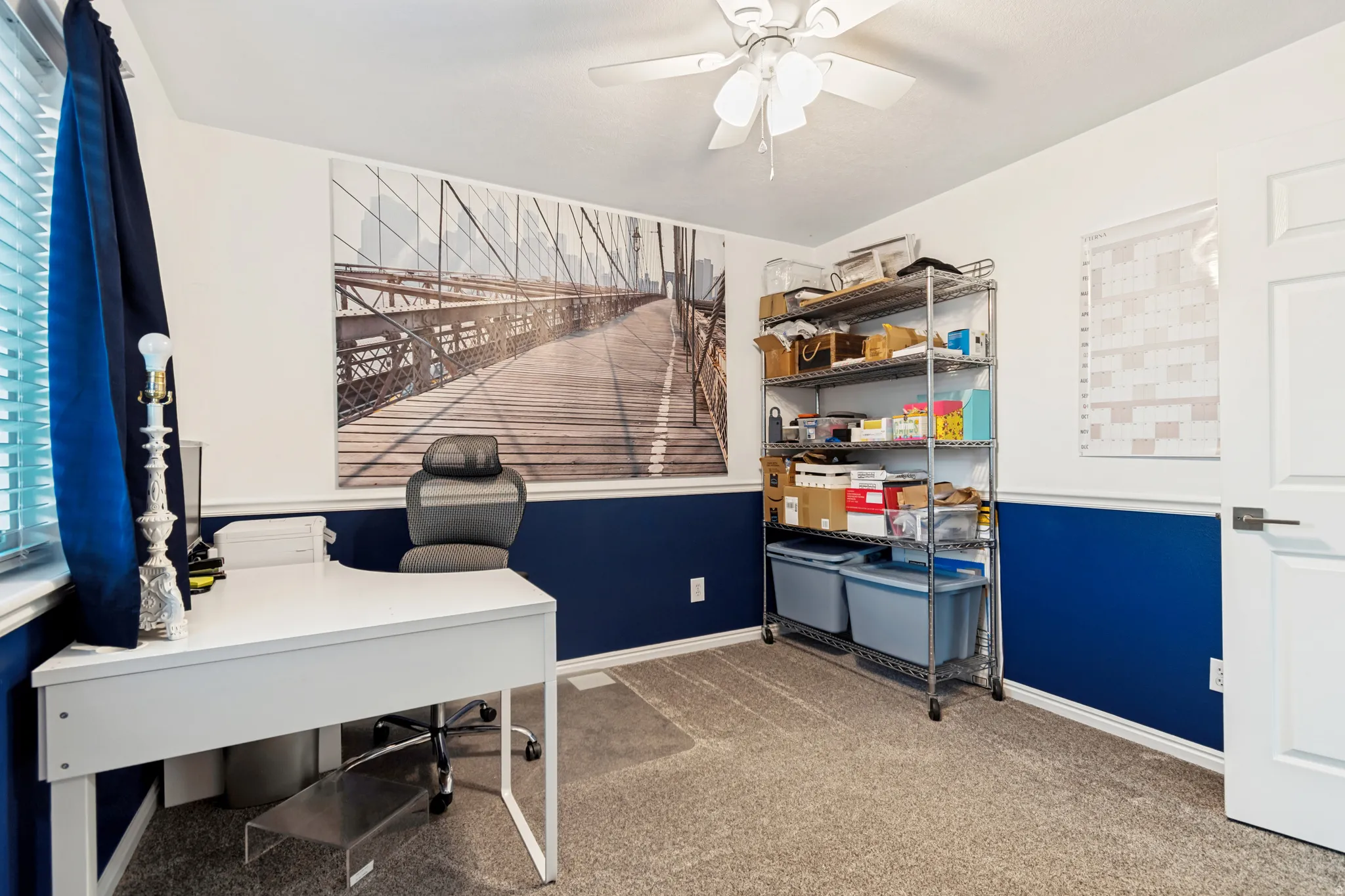 Carpeted interior room with white walls and a blue accent wainscoting