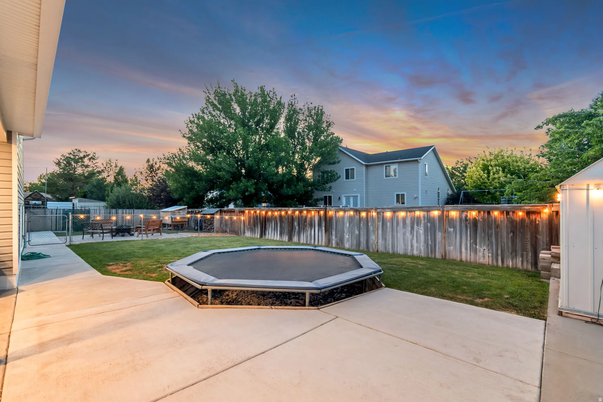 Expansive concrete patio with a manicured lawn and privacy fencing