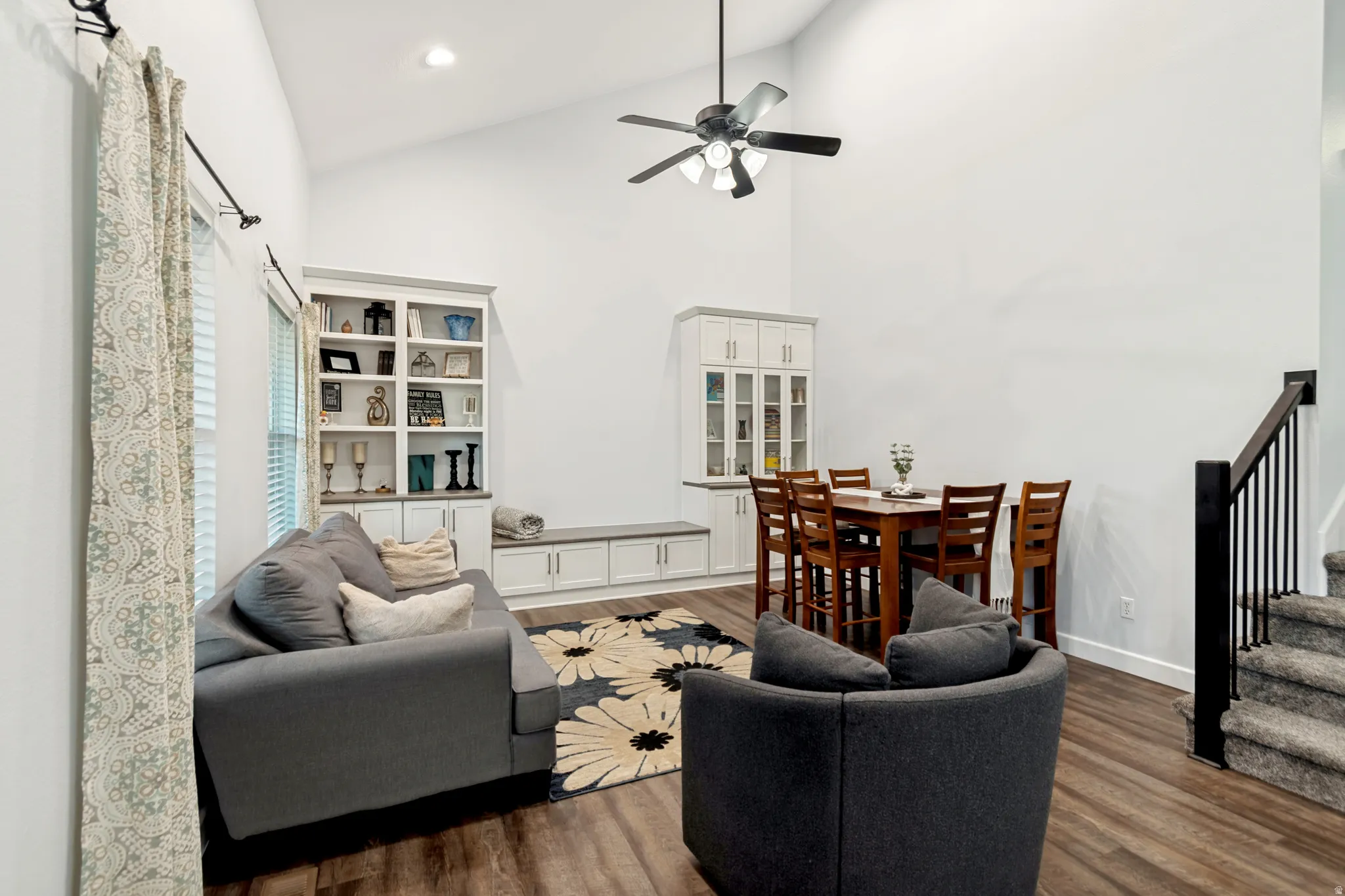 Vaulted ceilings enhance this open concept area featuring wood-finish flooring, a contemporary ceiling fan, and recessed lighting