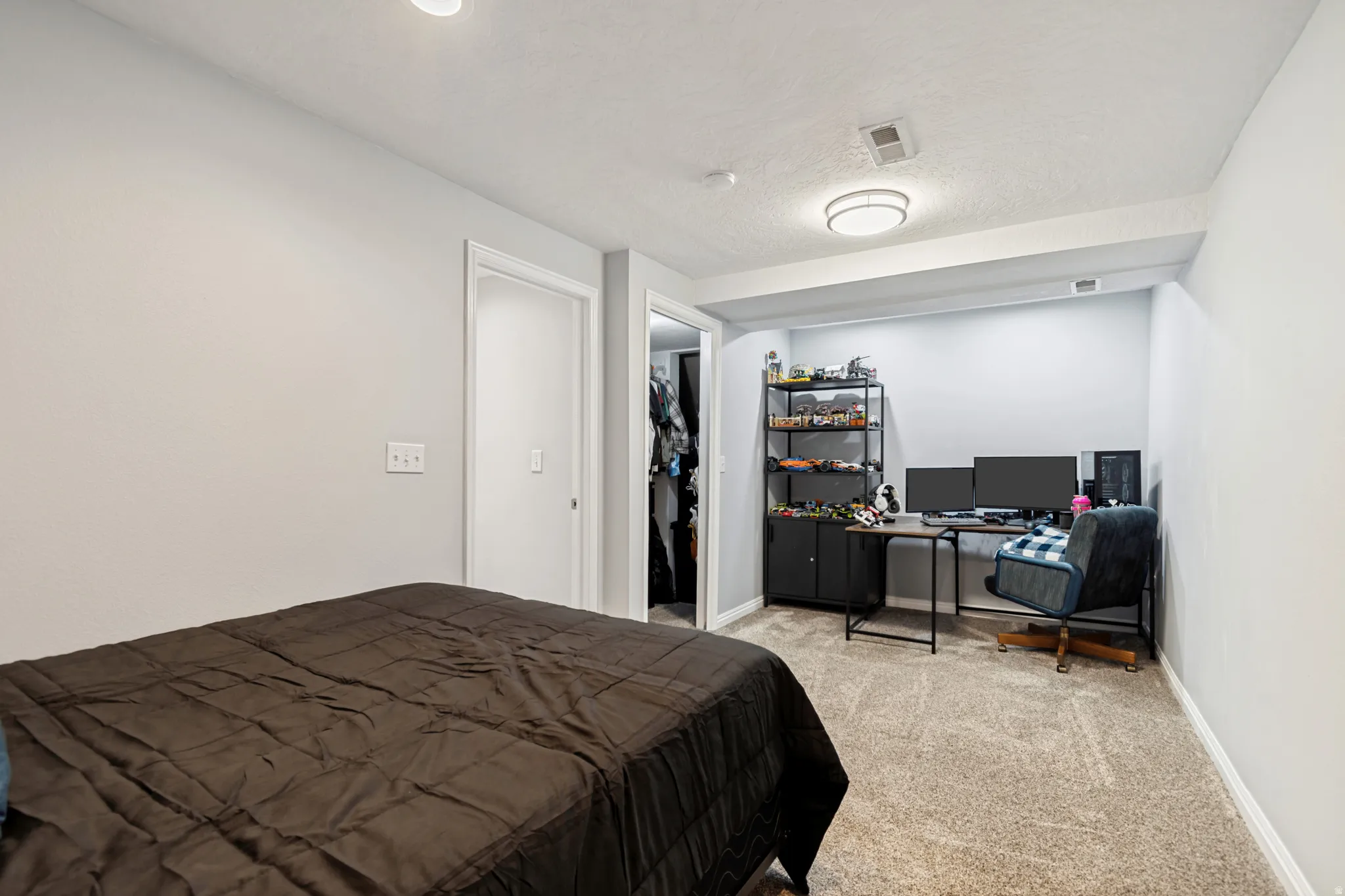 Carpeted room featuring light gray walls, white trim, and a recessed alcove