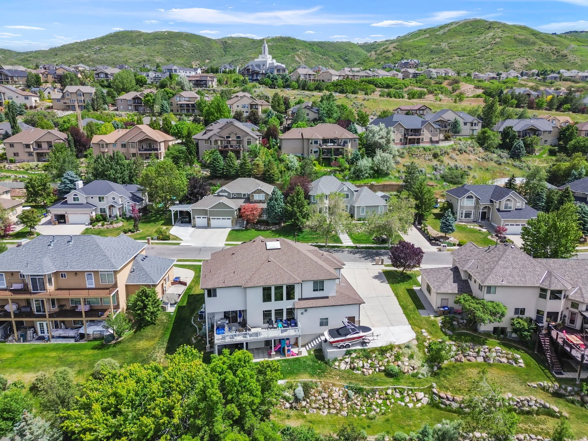 Spacious hillside residence featuring multiple decks, a walk-out lower level, and a multi-car driveway
