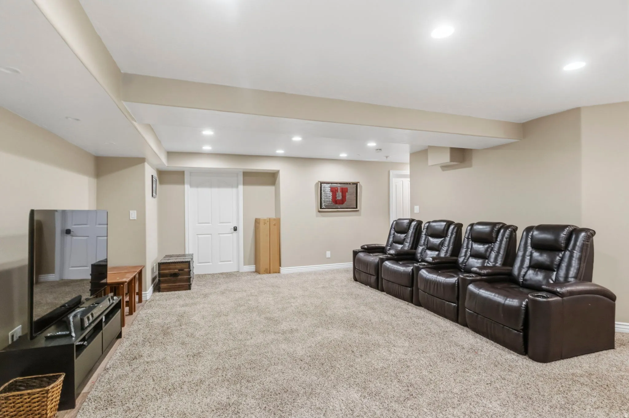 Spacious room featuring neutral wall tones and a light-toned carpet